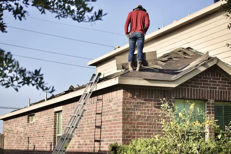 Professional roofer working on a residential roof in East Plumville